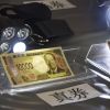Polisi menggunakan lampu untuk menunjukkan perbedaan antara uang kertas baru Polisi menggunakan lampu untuk menunjukkan perbedaan antara uang kertas baru