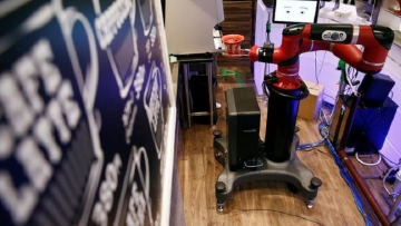 The robot barista called "Sawyer" makes a coffee during its demonstration at "Henn-na Cafe," meaning "Strange Cafe" in Japanese, in Tokyo
