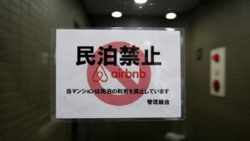 a-sign-communicating-the-ban-on-using-the-apartment-building-as-airbnb-service-by-the-building-management-is-attached-to-the-buildings-front-door-in-tokyo-japan