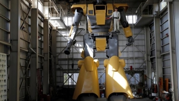 Sakakibara Kikai's engineer Go Sakakibara poses with the bipedal robot Mononofu during its demonstration at its factory in Shinto Village