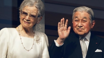 Empress Emerita Michiko and Emperor Emeritus Akihito wave to well-wishers during a public appearance for New Year celebrations at the Imperial Palace in Tokyo
