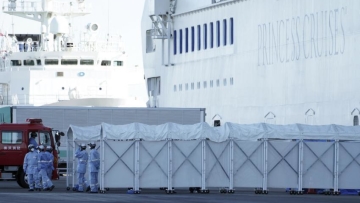Petugas berdiri di depan Kapal Pesiar Princess Cruise yang dikarantina di Yokohama