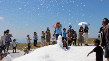 Salju buatan menghibur para pengunjung di tengah musim panas yang terik di Unpenji Summit Park Unpenji Summit Par