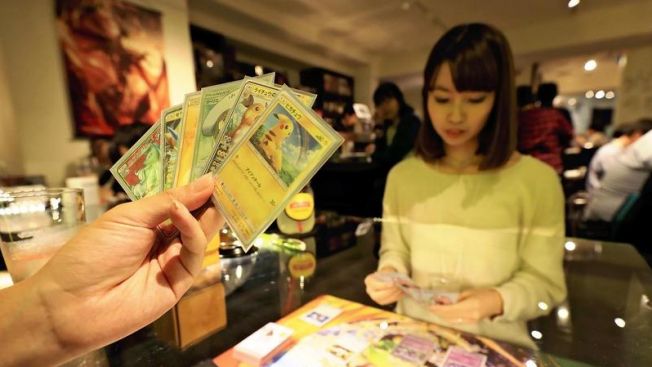 Seseorang sedang bermain kartu Pokemon di Shibuya,Tokyo. The Japan News
