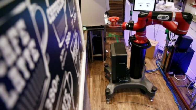 The robot barista called "Sawyer" makes a coffee during its demonstration at "Henn-na Cafe," meaning "Strange Cafe" in Japanese, in Tokyo