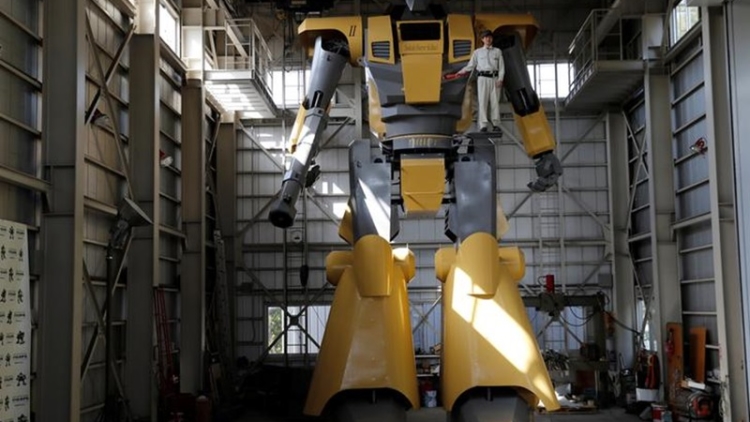 Sakakibara Kikai's engineer Go Sakakibara poses with the bipedal robot Mononofu during its demonstration at its factory in Shinto Village