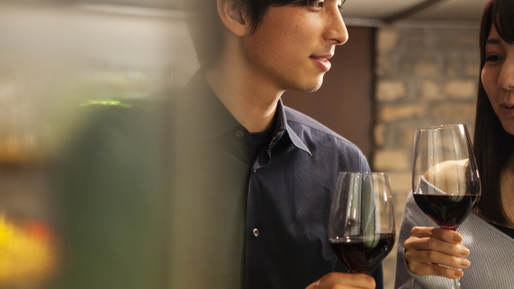 Men and women drinking while standing at a bar counter