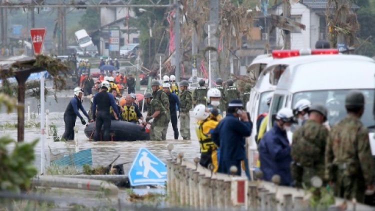 Tim penyelamat tengah menyelamatkan korban bencana banjir Kumamoto. Banjir Kumamoto
