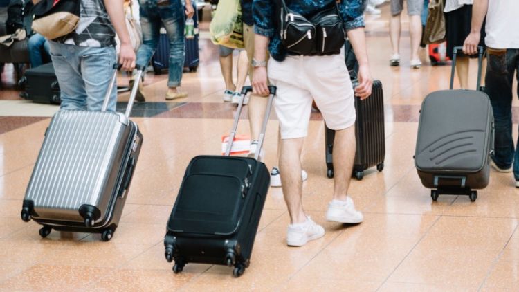 Wisatawan membawa koper. Pakutaso.com