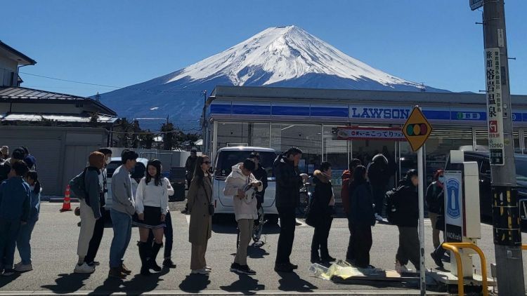 Pengunjung Mengambil Foto di Depan Lawson dengan Pemandangan Gunung Fuji Pengunjung Mengambil Foto di Depan Lawson dengan Pemandangan Gunung Fuji