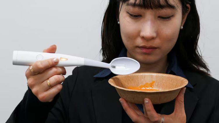 Seorang pegawai Kirin Holdings melakukan demonstrasi penggunaan sendok listrik (Reuters).