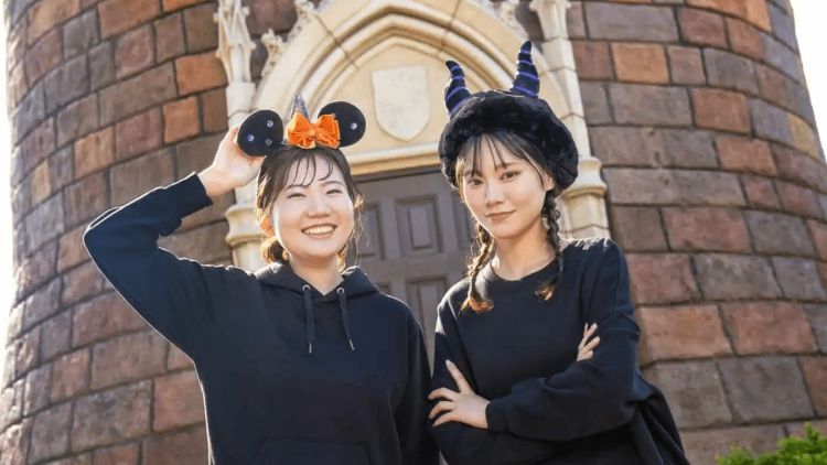 Dua orang perempuan berfoto dengan menggunakan ikat kepala spesial Halloween