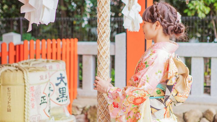 Ilustrasi. Seorang gadis berpakaian kimono berdoa ddi sebuah kuil