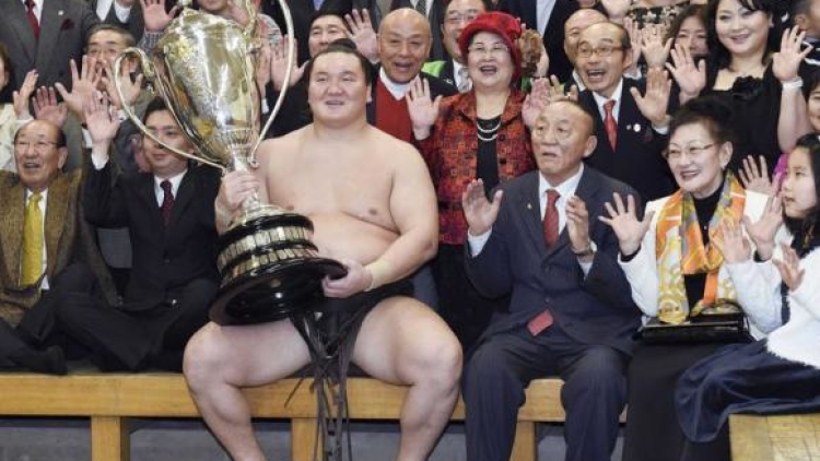 Mongolian-born grand sumo champion Yokozuna Hakuho holding the Emperor's Cup, celebrates with his supporters after winning the 15-day New Year Grand Sumo Tournament in Tokyo