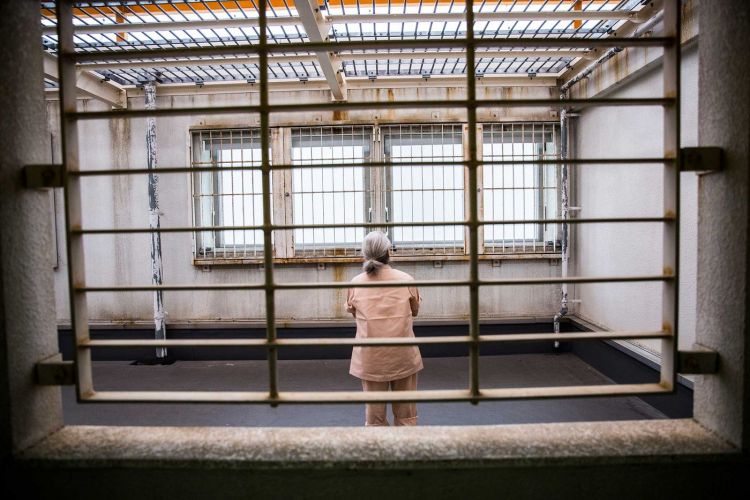 Seorang tahanan lansia dari balik jeruji besi (bloomberg.com)