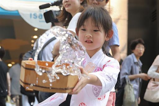 Seorang anak di Tokyo melakukan uchimizu (Xinhuanet).