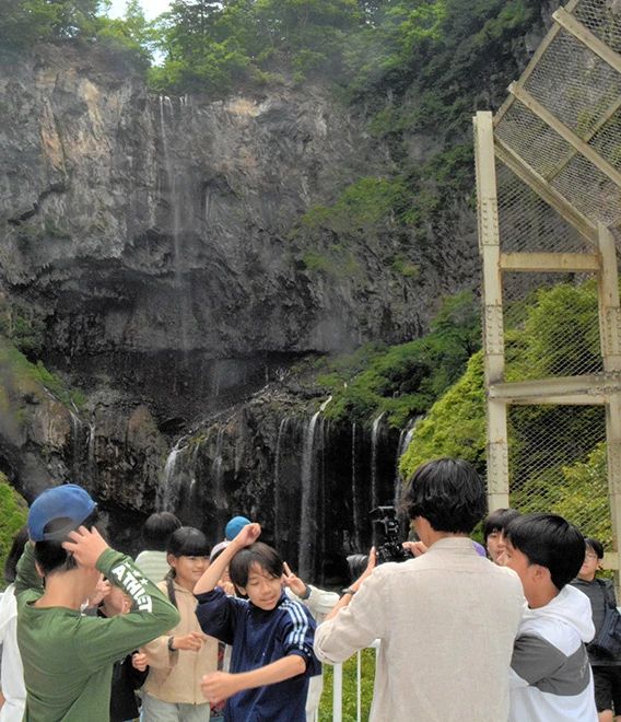 Anak-anak yang sedang dalam perjalanan sekolah, berpose di depan Air Terjun Kegon,