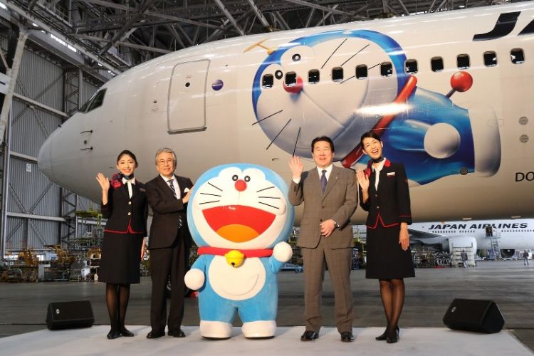 Doraemon berfoto dengan Direktur Fujiko F Fujio Pro, pejabat JAL dan kedua pramugari