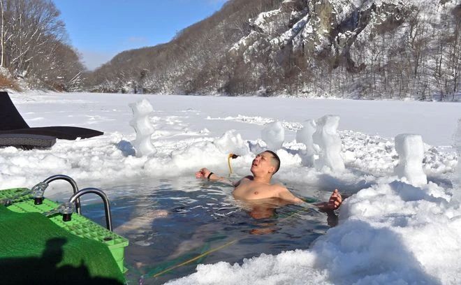 Seorang pria berendam di Danau Kuttari yang membeku (Asahi ShimbunShigehito Nakazawa)